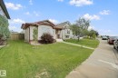Manicured front lawn with a concrete walkway and mature shrubbery - 13912 156 Avenue Nw, Edmonton, AB 