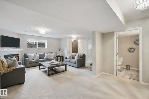 Spacious recreational area featuring recessed lighting, a built-in fireplace with a hearth, and plush carpeting - 13912 156 Avenue Nw, Edmonton, AB 