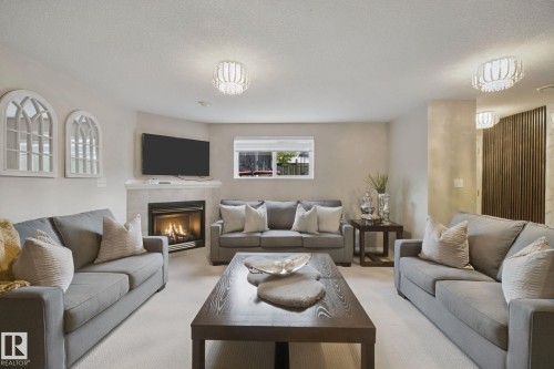 Recessed lighting, contemporary flush-mount light fixtures, corner fireplace with tile surround, built-in shelving, and a horizontal window - 13912 156 Avenue Nw, Edmonton, AB 