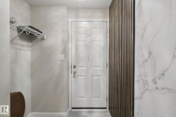 White panel door with brass hardware, wall-mounted wire shelving, and wood-slat accent wall - 