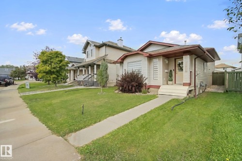 Single-story residence featuring light-colored siding, a brown roof, and a front porch - 13912 156 Avenue Nw, Edmonton, AB 