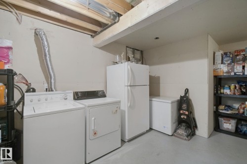 Laundry area featuring a washer and dryer, exposed ceiling joists, and a concrete floor - 13912 156 Avenue Nw, Edmonton, AB 
