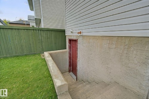 Exterior with concrete basement access and red door - 13912 156 Avenue Nw, Edmonton, AB 