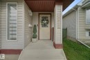 Covered front porch with light-toned siding, white trim, and a full-light entry door - 13912 156 Avenue Nw, Edmonton, AB 