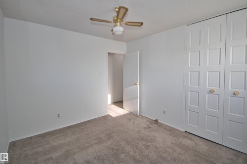 Carpeted flooring, white walls, ceiling fan, and bi-fold closet doors - 7743 37 Avenue Nw, Edmonton, AB 