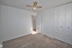 Carpeted flooring, white walls, ceiling fan, and bi-fold closet doors - 