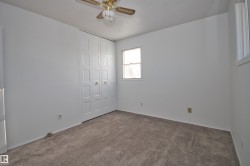 Neutral wall palette, soft carpet flooring, bi-fold closet doors, ceiling fan, and multiple windows - 