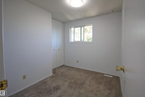 Neutral wall finishes, carpeted flooring, and a flush-mount ceiling light - 7743 37 Avenue Nw, Edmonton, AB 