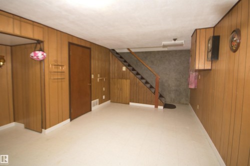 Finished lower level with paneled walls, light-toned flooring, and built-in cabinetry - 7743 37 Avenue Nw, Edmonton, AB 