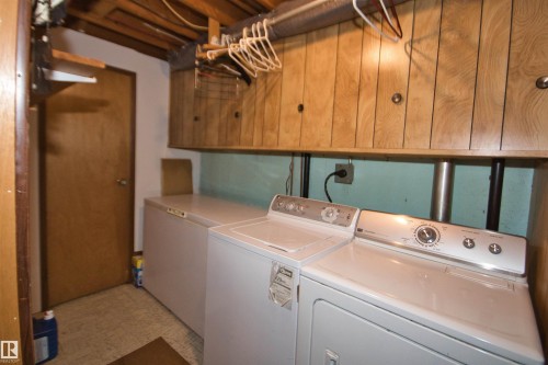 Wood-finish wall paneling, overhead wood cabinetry, and a ceiling-mounted light fixture - 7743 37 Avenue Nw, Edmonton, AB 