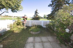Backyard space featuring concrete patio pavers, a raised garden bed, and a privacy fence - 