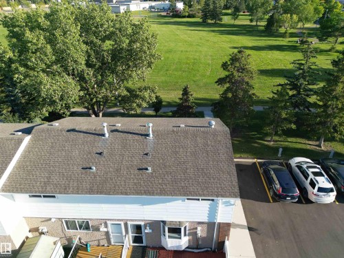 Paved parking area, mature trees, and expansive green space - 7743 37 Avenue Nw, Edmonton, AB 