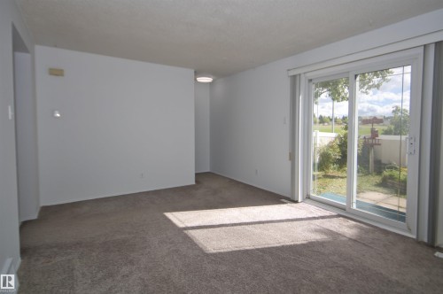 Sliding glass door, wall-to-wall carpeting, overhead lighting fixture, white walls, enclosed backyard with fencing - 7743 37 Avenue Nw, Edmonton, AB 