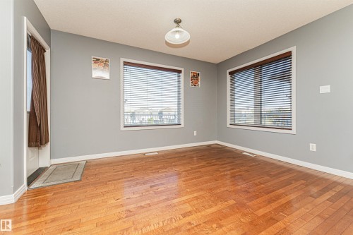 Wood-finish flooring, multiple windows with blinds, and an overhead light fixture - 1254 Mcallister Way Sw, Edmonton, AB 
