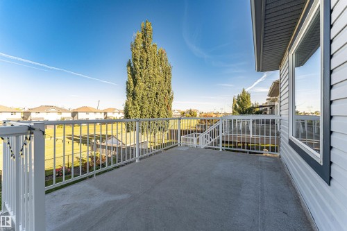 Concrete deck with white railing, featuring a large exterior window and horizontal siding - 1254 Mcallister Way Sw, Edmonton, AB 