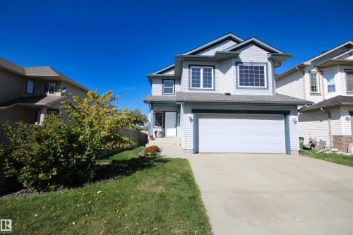 Two-story property with light-colored siding, a prominent attached garage, and a concrete driveway - 1254 Mcallister Way Sw, Edmonton, AB 