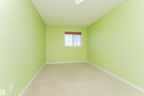 Carpeted room with a window, white trim, and a ceiling-mounted light fixture - 1254 Mcallister Way Sw, Edmonton, AB 