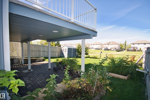 Covered patio with paver flooring, overhead lighting, and white lattice detailing - 1254 Mcallister Way Sw, Edmonton, AB 