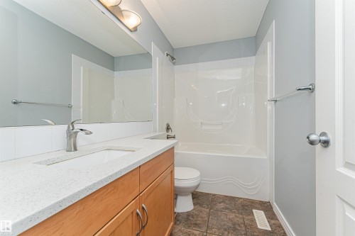 Vanity with a light wood finish, white countertop, and integrated sink - 1254 Mcallister Way Sw, Edmonton, AB 