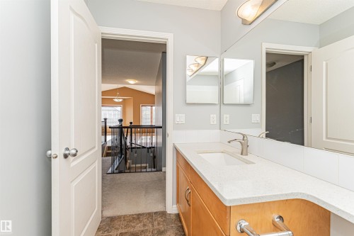 Bathroom vanity with a white countertop, undermount sink, and brushed nickel faucet - 1254 Mcallister Way Sw, Edmonton, AB 