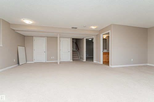 Expansive carpeted area with neutral wall tones and white trim - 1254 Mcallister Way Sw, Edmonton, AB 