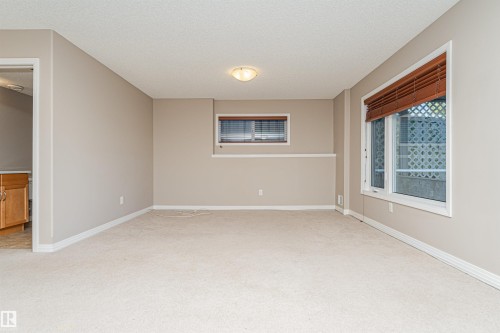 Carpeted flooring, neutral wall tones, recessed ceiling lighting, and a large window with privacy blinds - 1254 Mcallister Way Sw, Edmonton, AB 