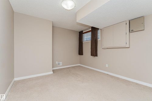 Wall-to-wall carpeted flooring with light-toned wall finishes, recessed ceiling light fixture, and window with blinds - 1254 Mcallister Way Sw, Edmonton, AB 