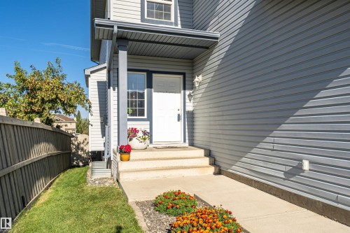 Light grey siding exterior with white trim windows and a covered front entry - 1254 Mcallister Way Sw, Edmonton, AB 