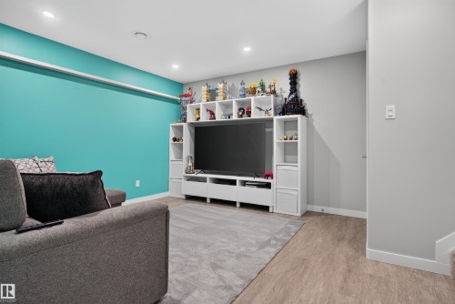 Recessed lighting, wood-finish flooring, and built-in shelving with integrated media console - 319 Desrochers Boulevard Sw, Edmonton, AB 
