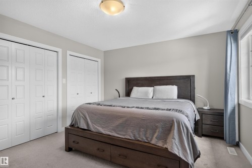 Two sets of bi-fold closet doors, wall-to-wall carpeting, and a window with curtain rod - 319 Desrochers Boulevard Sw, Edmonton, AB 