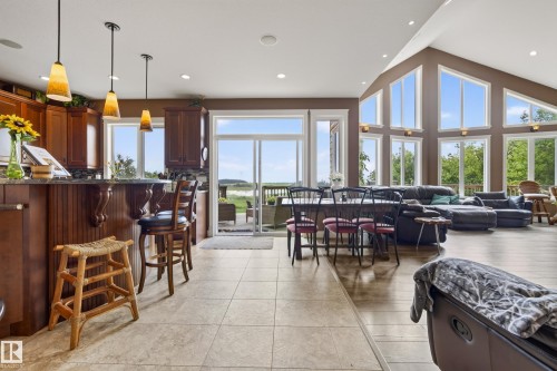 Vaulted ceiling great room featuring expansive windows, recessed lighting, wood-finish flooring, and direct patio access - 48109 Rr 155, Rural Beaver County, AB - Indoor