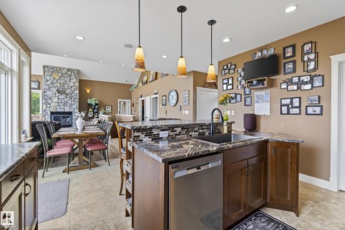 Kitchen island with integrated stainless steel dishwasher, undermount sink, and black faucet - 48109 Rr 155, Rural Beaver County, AB - Indoor Photo Showing Kitchen With Upgraded Kitchen