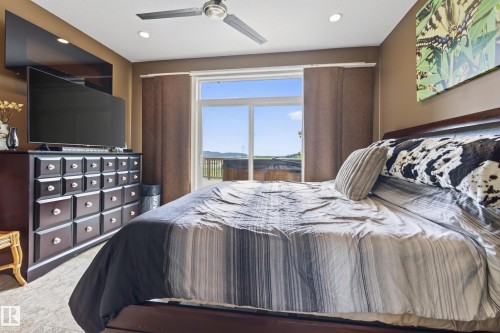 Glass sliding door accessing an outdoor deck area with distant landscape - 48109 Rr 155, Rural Beaver County, AB - Indoor Photo Showing Bedroom