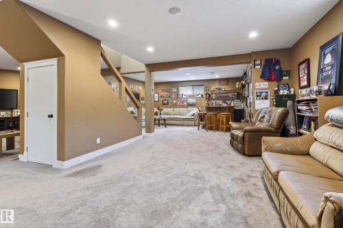 Spacious lower-level entertainment area featuring recessed lighting, light-toned carpeting, and a built-in wet bar with wood cabinetry and bar seating - 48109 Rr 155, Rural Beaver County, AB - Indoor