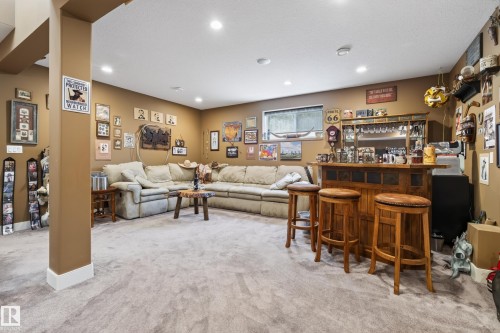Finished basement featuring recessed lighting, a built-in bar with shelving, a window, and neutral carpeting - 48109 Rr 155, Rural Beaver County, AB - Indoor
