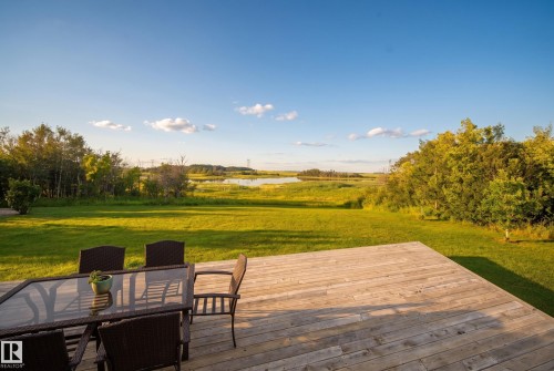 Expansive wood-finish deck overlooking a substantial green lawn and natural water feature - 48109 Rr 155, Rural Beaver County, AB - Outdoor With Deck Patio Veranda With View
