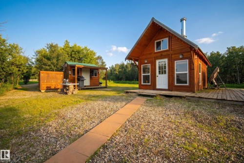 Wood-clad main structure with an A-frame roof, white-framed windows, and a white paneled entry door - 48109 Rr 155, Rural Beaver County, AB - Outdoor