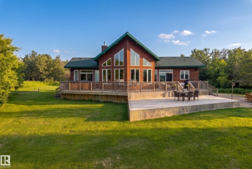Wood-sided residence featuring a large multi-level deck, expansive windows, and a prominent gable roof - 48109 Rr 155, Rural Beaver County, AB - Outdoor With Deck Patio Veranda