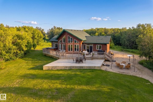 Spacious outdoor living featuring a multi-level wood deck, a ground-level patio, and a separate paved seating area - 48109 Rr 155, Rural Beaver County, AB - Outdoor With Deck Patio Veranda