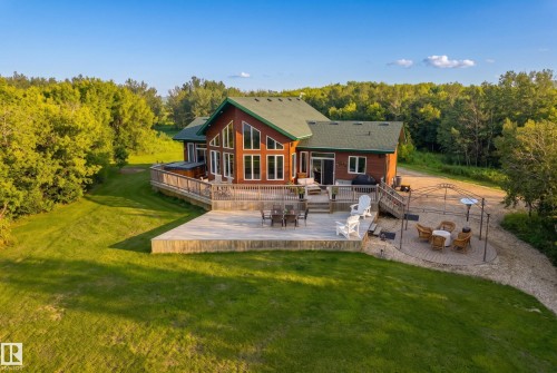Expansive wood-sided home featuring a green shingle roof and abundant glazing - 48109 Rr 155, Rural Beaver County, AB - Outdoor With Deck Patio Veranda