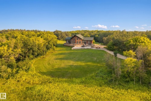 Expansive green lawn surrounds a wood-sided residence with a dark green roof - 48109 Rr 155, Rural Beaver County, AB - Outdoor With View
