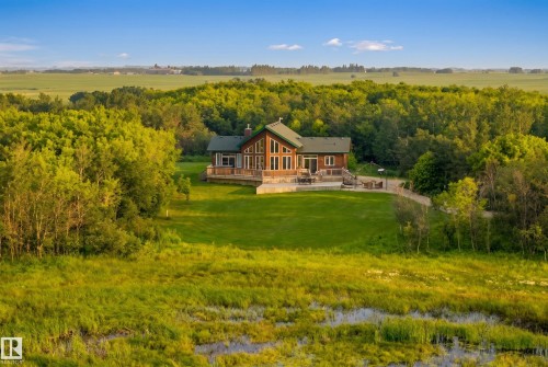 Rustic-modern residence featuring a prominent A-frame window design and a broad wooden deck - 48109 Rr 155, Rural Beaver County, AB - Outdoor With Deck Patio Veranda With View