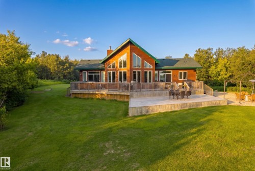 Wood-sided residence featuring a green roof and a prominent A-frame window design - 48109 Rr 155, Rural Beaver County, AB - Outdoor With Deck Patio Veranda