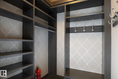 Custom built-in shelving, integrated hanging rod, and decorative wall covering - 886 Armitage Wynd Sw, Edmonton, AB 