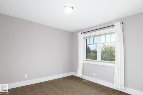 Neutral wall paint, ceiling-mounted light fixture, white trim, and carpeted flooring - 886 Armitage Wynd Sw, Edmonton, AB 