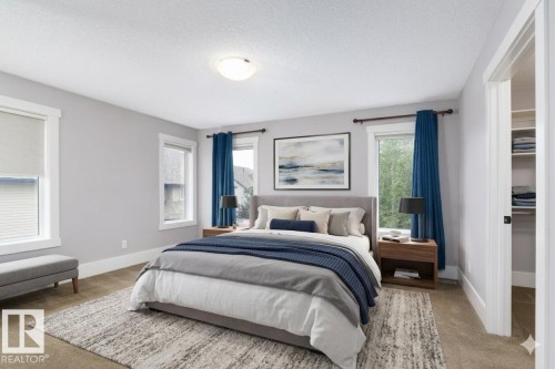 Recessed ceiling light fixture, multiple windows with white trim, built-in closet shelving, light-colored wall paint, and carpeted flooring - 886 Armitage Wynd Sw, Edmonton, AB 