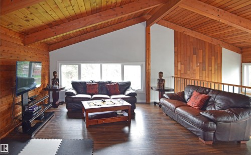 Vaulted wood-finish ceilings with exposed beams, wood-finish walls, wood-finish flooring, and a large multi-pane window - 9657 68A Street Nw, Edmonton, AB 