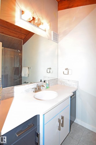 Vanity with an integrated sink, brushed nickel faucet, and a subway tile backsplash - 9657 68A Street Nw, Edmonton, AB 