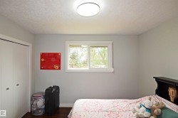 Light gray walls, white trim, wood-finish flooring, white bi-fold closet doors, and an overhead flush-mount light fixture - 