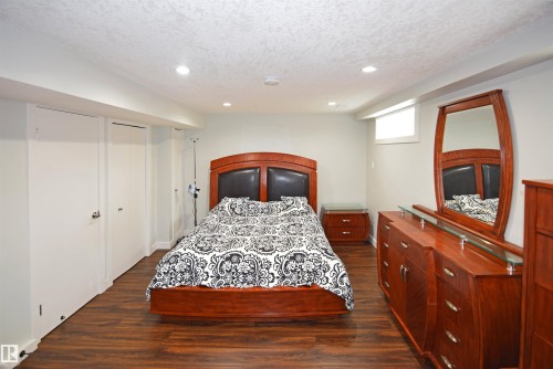 Wood-finish flooring, recessed ceiling lighting, a window, and white paneled closet doors - 9657 68A Street Nw, Edmonton, AB 